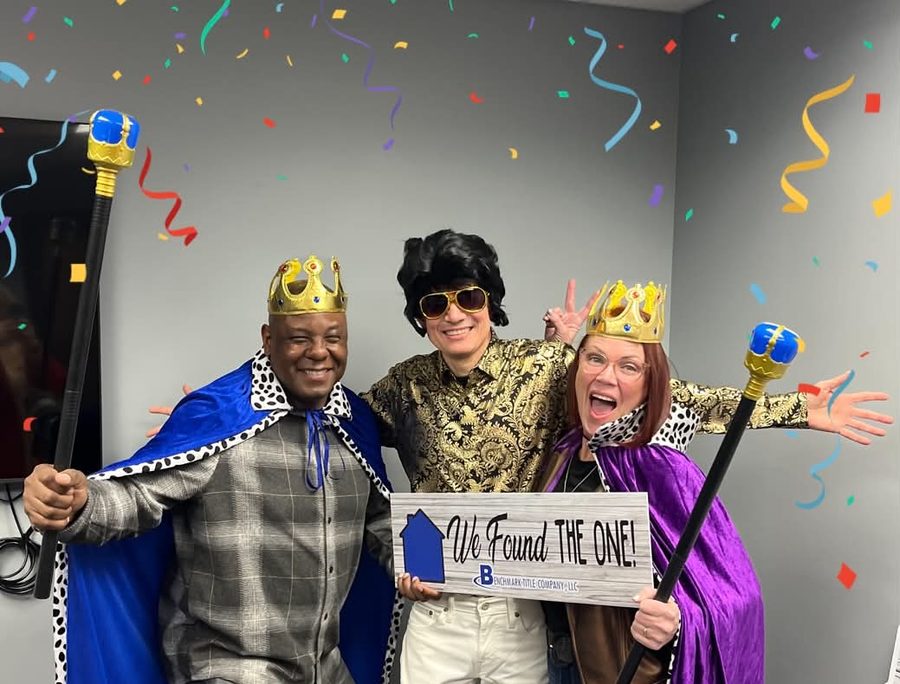 Gary Seid in a gold shirt and Elvis wig with Angelina and her partner wearing king and queen crowns, holding a 'We Found The One' sign on closing day